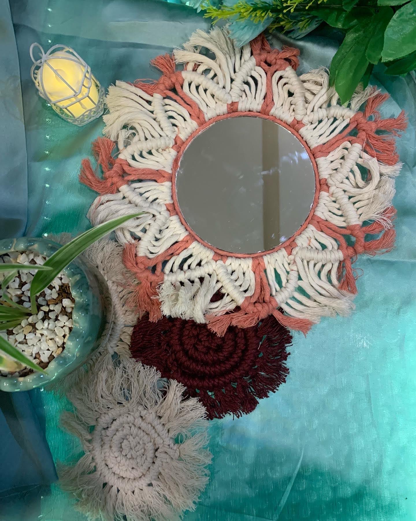 Sun-shaped macramé mirror in coral and ivory with fringed coasters
