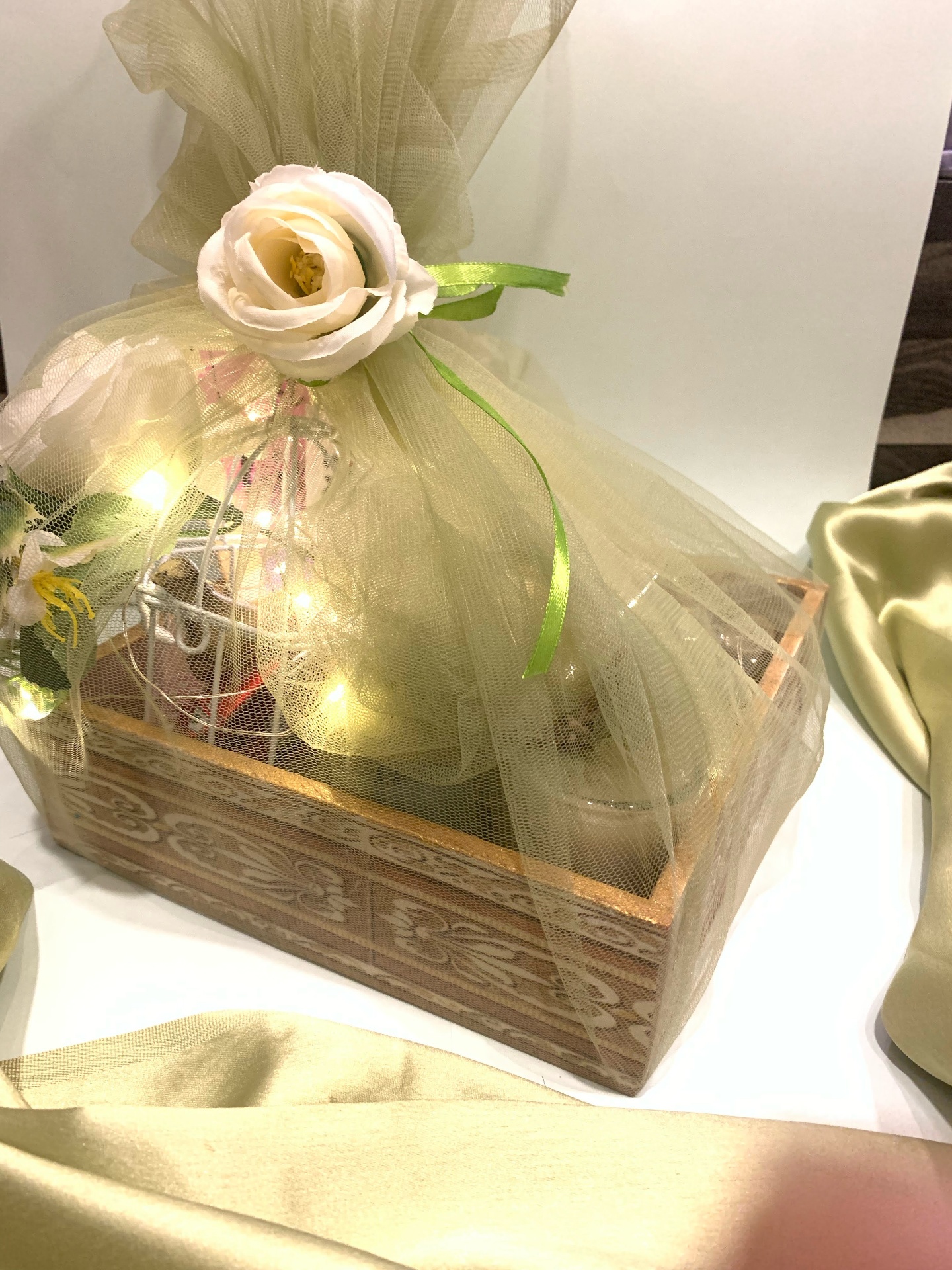Wooden hamper with fairy lights wrapped in soft golden tulle