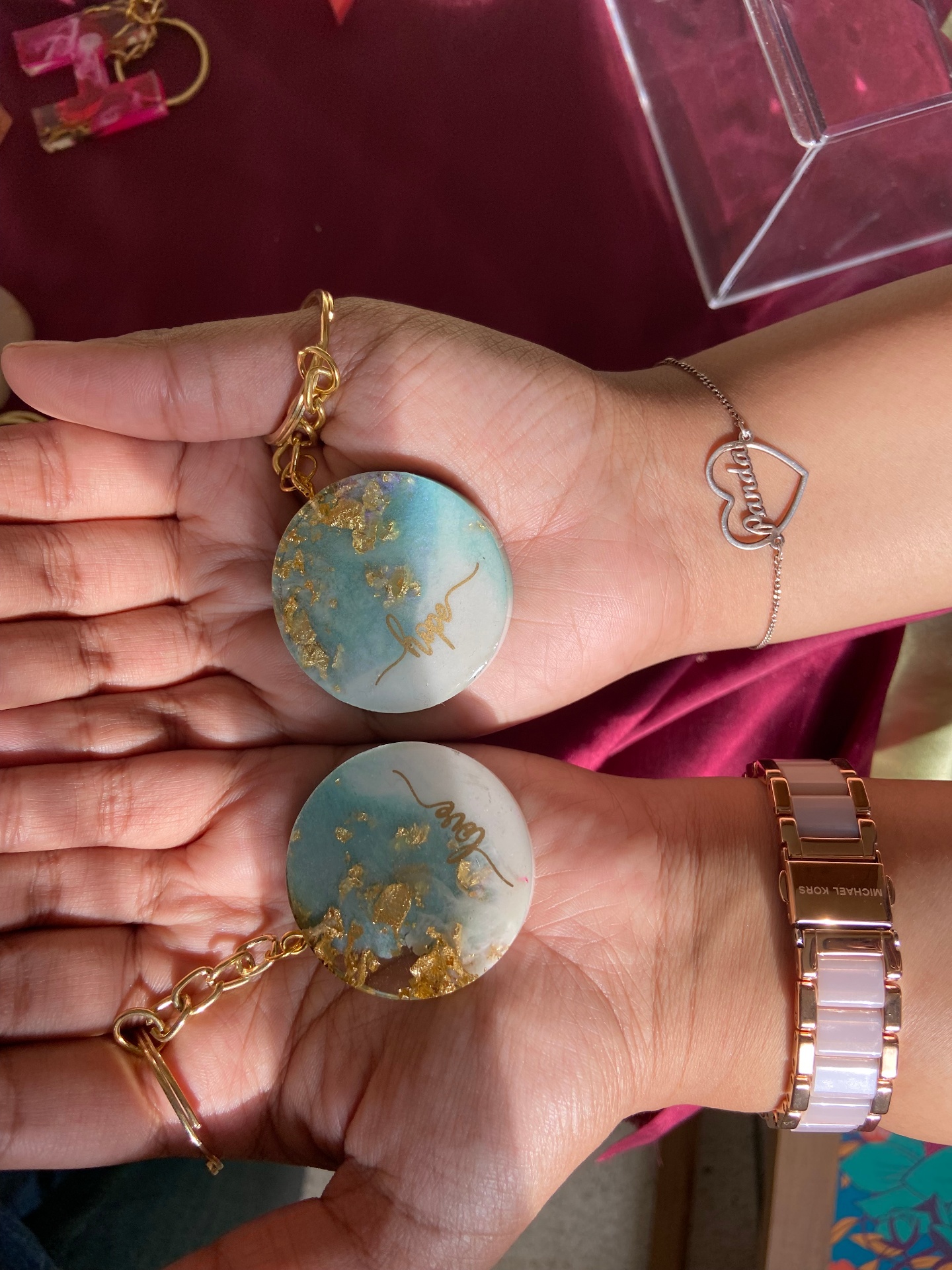 Hope and love round resin keychains with gold flakes on a hand