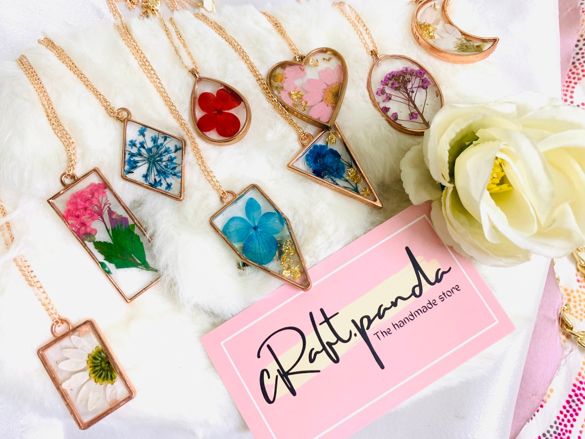 Flatlay of handmade resin pendants with pressed flowers